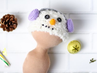 Шапка в'язана ручної роботи для ляльки - Сніговик у бузкових навушниках 215936372 фото